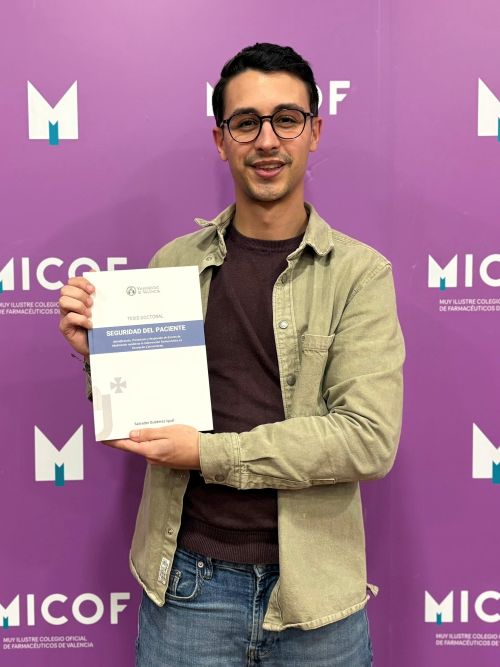 photograph of Salvador with the thesis book in his hand